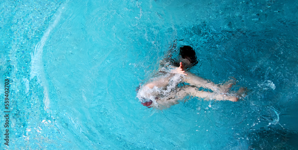 top view to young sexy bikini woman in turquoise pool spa has fun under water and reaches hand out to you and invites you