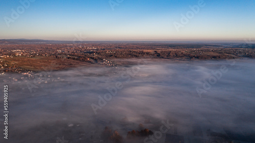 Photo from a drone over the village when the fog fell with thick clouds, a beautiful morning over the village.