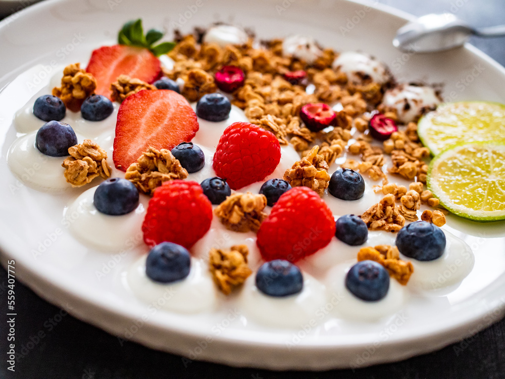 Yogurt with strawberries, blueberries, raspberries and muesli in bowl on wooden table
Yogurt with strawberries, blueberries, raspberries and muesli in bowl on wooden table