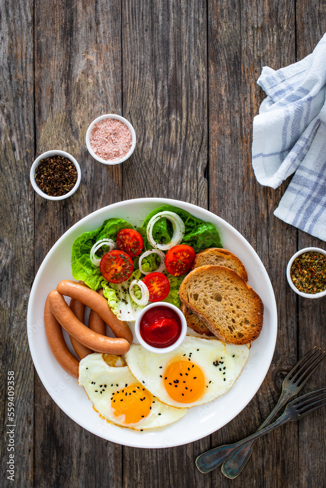 Breakfast - sunny side up egg, boiled sausages and vegetables served on wooden table
Breakfast - sunny side up egg, boiled sausages and vegetables served on wooden table