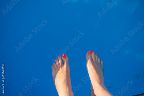 woman legs in blue water with a white background