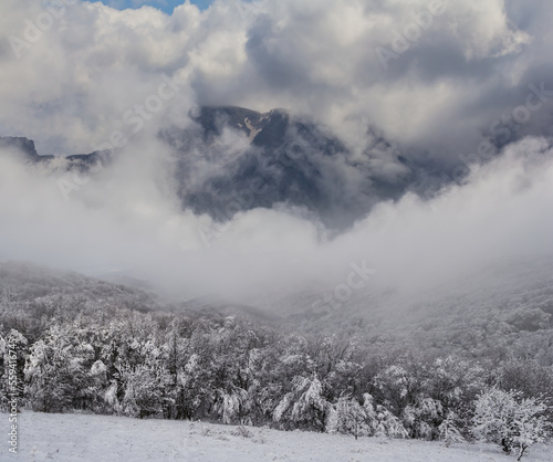 snowbound mountain valley in dense clouds and mist