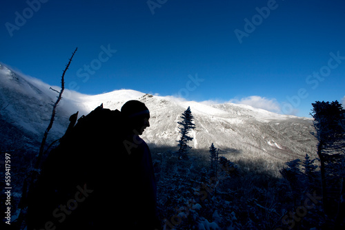 A man hikes the Boott Spur Link as a storm clears, revealing Tuckerman's Ravine and the summit of Mt. Washington. photo