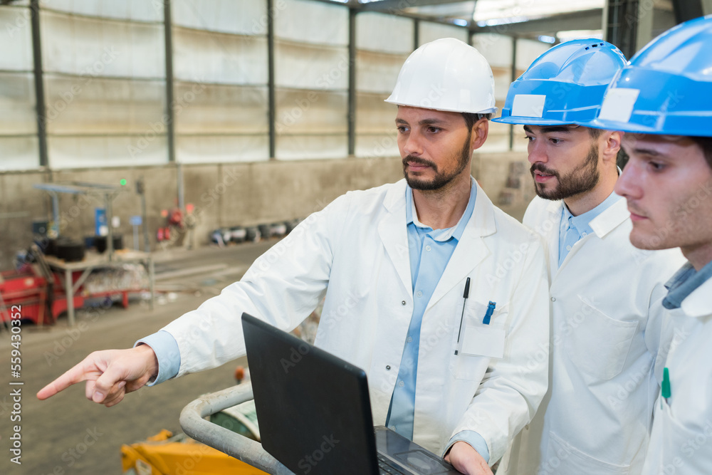 businessman and engineers working with laptop in factory businessman and engineers working with laptop in factory