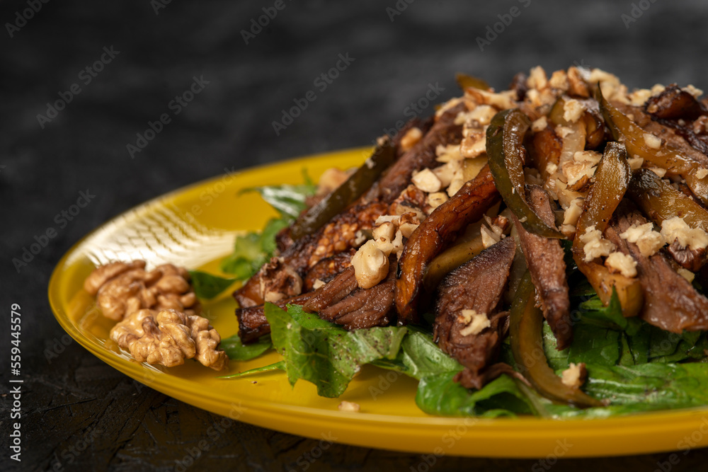 beef salad with vegetables and walnut on black background beef salad with vegetables and walnut on black background