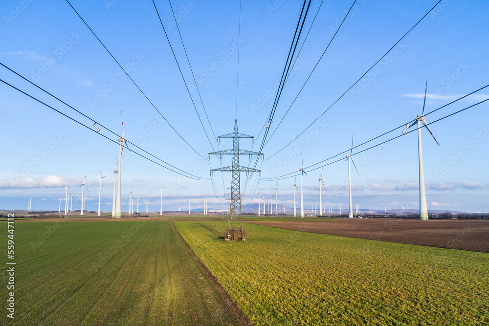 Cables and wires of an electrical power line with windmills for wind energy production