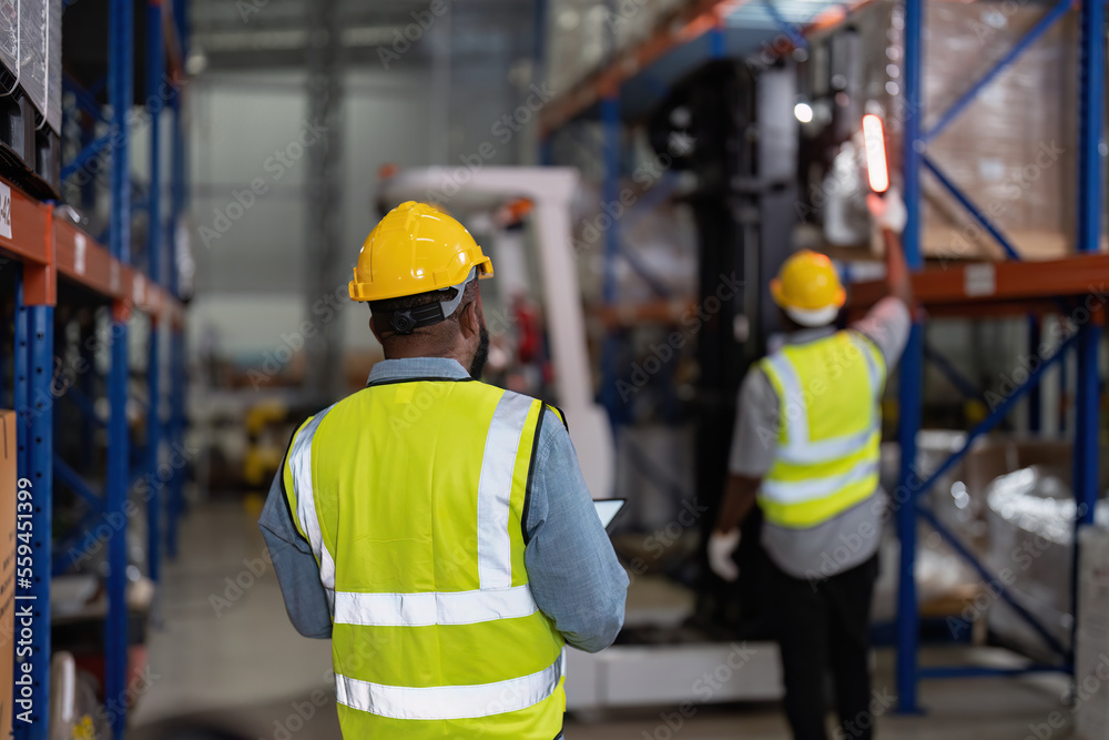 African american working in warehouse hold red light give signal to truck loading carton box African american working in warehouse hold red light give signal to truck loading carton box