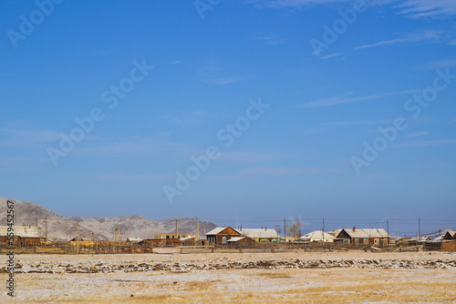 Scenic view of small village and snowcapped mountains in winter