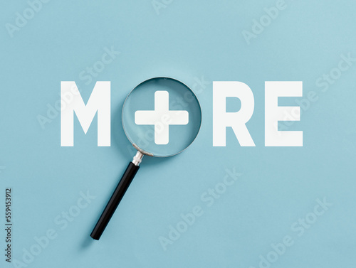Aspiring for more achievement or improvement. Value added. Raising the bar. Raising expectations or standards. The word more with a plus sign and magnifying glass. photo