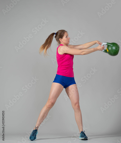 Training with kettlebells, a young athlete performs exercises with kettlebells, kettlebell lifting for the tone of the whole body
