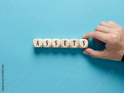 Business assets. Asset management and financial accounting concept. Male hand arranges the wooden cubes with the word assets.