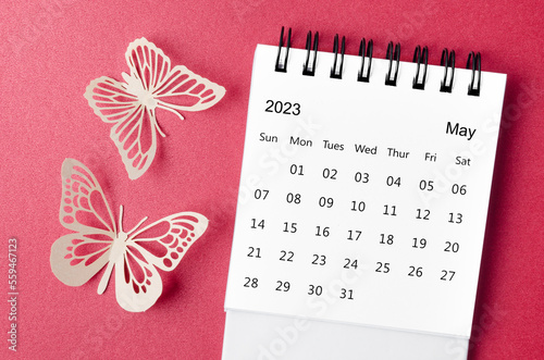 A May 2023 desk calendar for the organizer to plan and reminder with paer butterfly on red background. photo