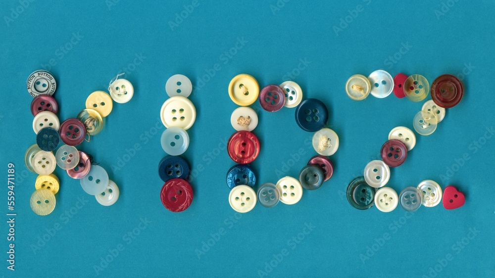Kids, colorful button badges, text over blue background. Collection of assorted spare clothes buttons vintage. Sewing tools close up framing fabric background. Kids, colorful button badges, text over blue background. Collection of assorted spare clothes buttons vintage. Sewing tools close up framing fabric background.