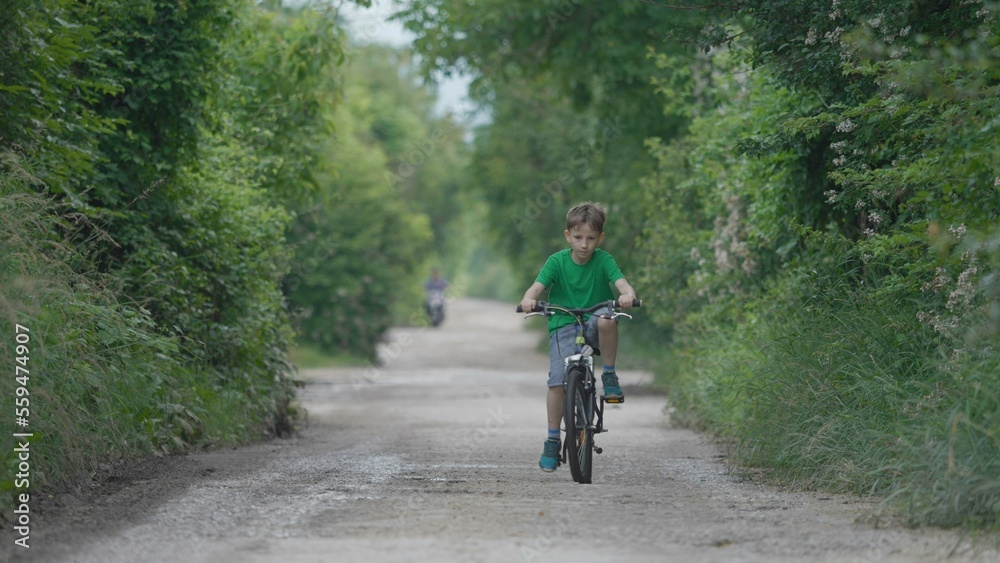 One child riding a bike on rural road, freedom play, active outdoor