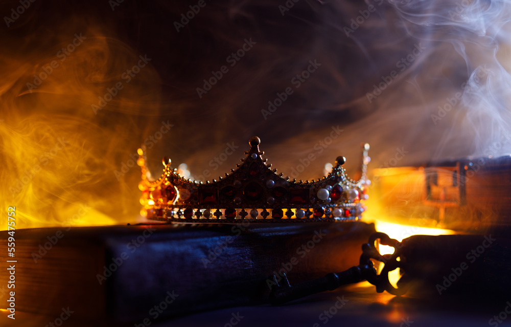 A golden crown, an old book, a key and old casket on a dark background. Panoramic view of the fog. Layout for your logo. A horizontal banner with a place to copy the cover image of a popular website.