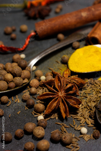 A set of different spices close-up on a dark table. Spice background. Banner. Oriental spice market. A set of peppers and spices for cooking. Indian spices set