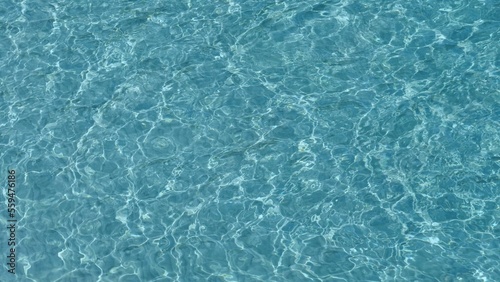 Abstract shapes of shallow blue clear sea water ripples on white fine beach sand