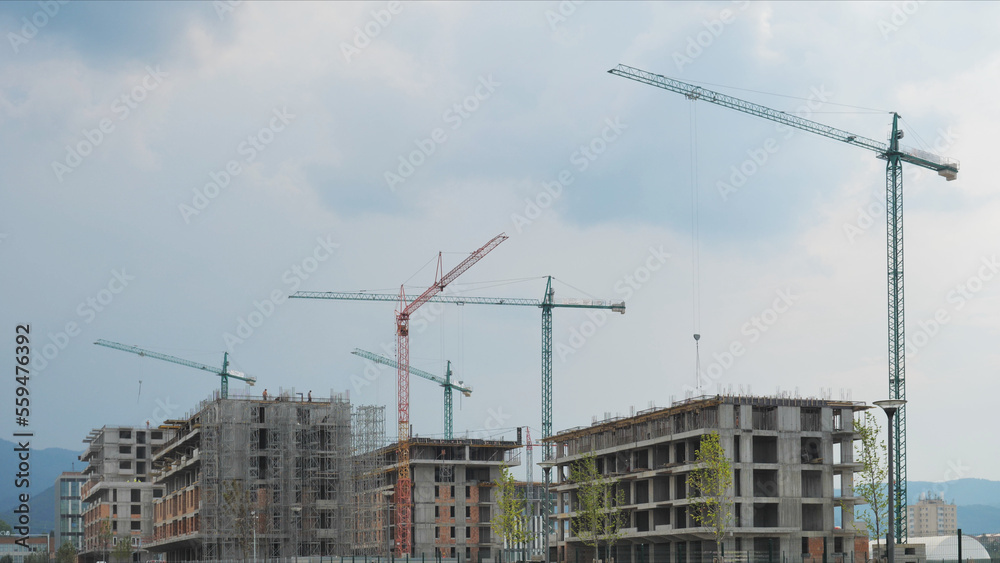 Cranes moving on the sky building new constructions, urban development Cranes moving on the sky building new constructions, urban development