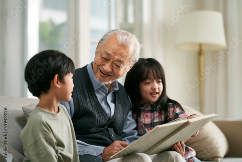 asian grandpa and two grandchildren having a good time at home photo