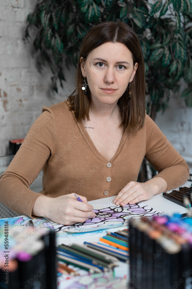 Fototapeta premium girl sitting at the table and drawing