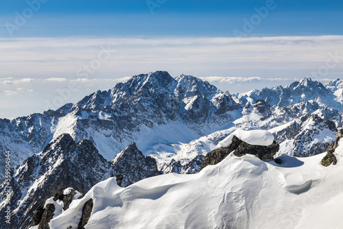 Snowy winter high mountain landscape. A panoramic view from the top of The Lomnicky peak in High Tatras National Park, Slovakia, Europe.