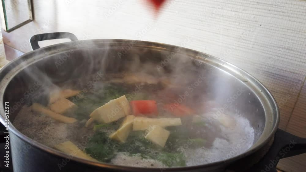 Cooking soup. Chef dropping chopped vegetables into boiling water in slow motion. High quality 4k footage