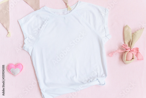 Easter mockup white t-shirt with bunny and easter eggs on pink cover background. Flatlay, top view, copyspace. © lusyaya