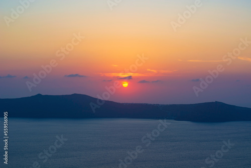 Colorful sunset over Santorini Caldera, Greece. Seascape with mountains and beautiful sky. One of the most iconic places in the world to watch the sun go down is Santorini. 