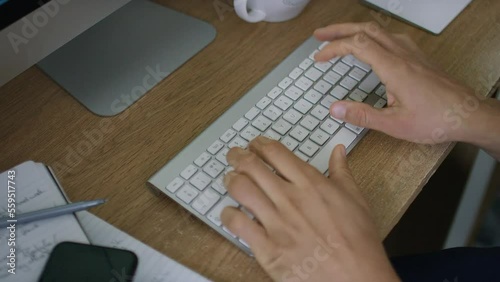 Hands of a man typing on a computer keyboard photo