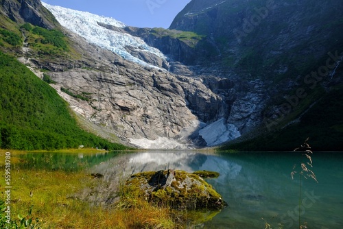 Boyabreen Glacier and a glacial lake Jostedalsbreen National Park in Norway. A small tent stands at the foot of the glacier.