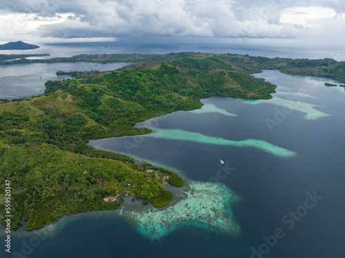 A scenic tropical island is fringed by a coral reef in the Solomon Islands. This beautiful country is home to spectacular marine biodiversity and many historic WWII sites.