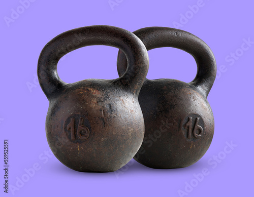 two black iron weights of 16 kg isolated on violet background.