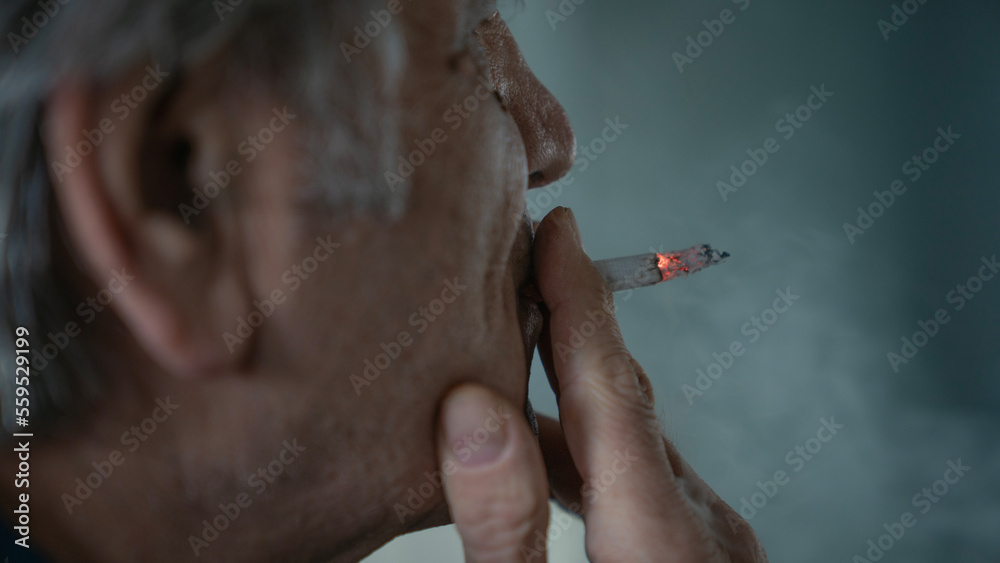 Fototapeta premium Old man smoking a cigarette