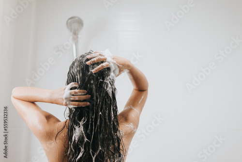Woman washing hair with shampoo and shower in bathroom, Asian female body and hair care with foam to freshness. Spa and Health care. photo