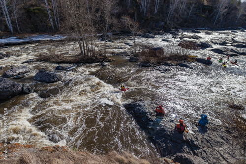 Water sports competitions on kayaks on a full-flowing river in spring