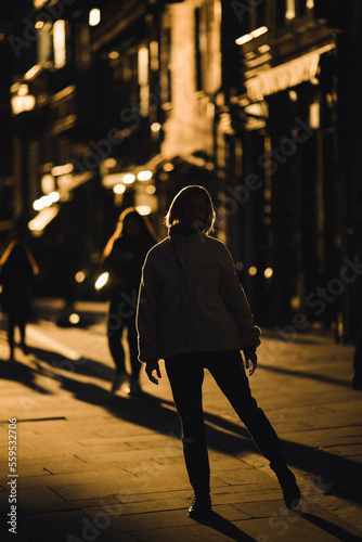 A woman on the street in the backlight during a golden sunset.. © De Visu
