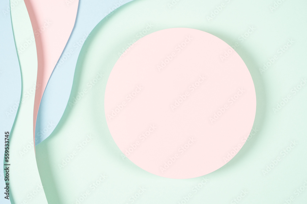 Blank pink round geometric shape podium platform on paper cut abstract geometric shape pastel pink, blue and green background. Top view mock up for product display