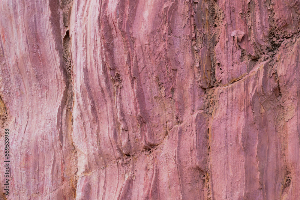 Naklejka premium Closeup of the pink colored rock wall background and texture with detailed