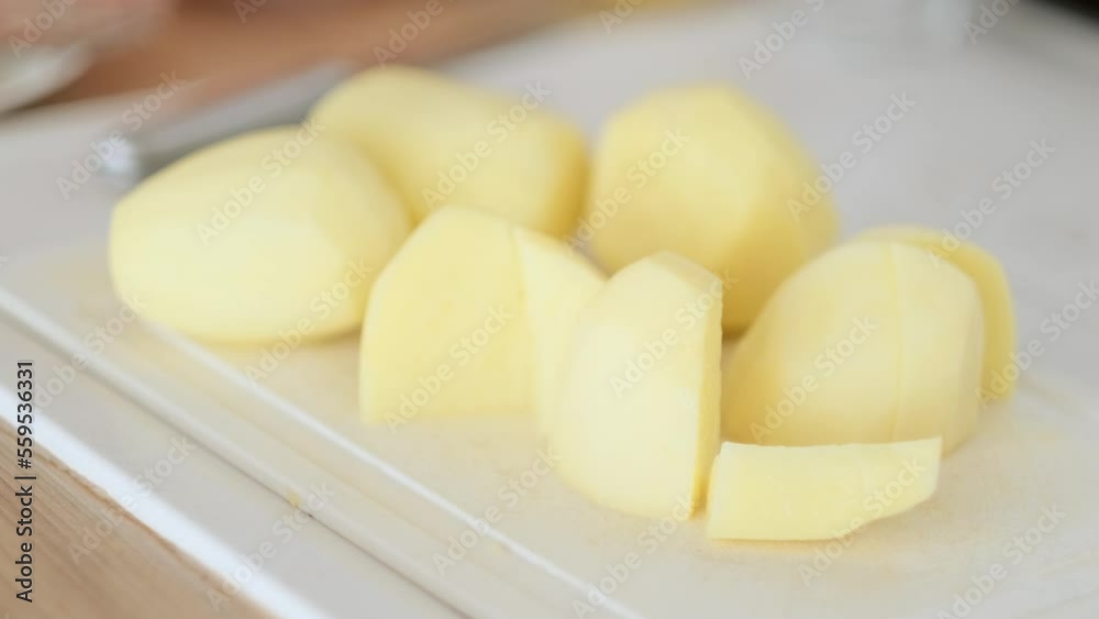 chopped raw potatoes on cutting board, cooking vegetables dinner in kitchen. chopped raw potatoes on cutting board, cooking vegetables dinner in kitchen.