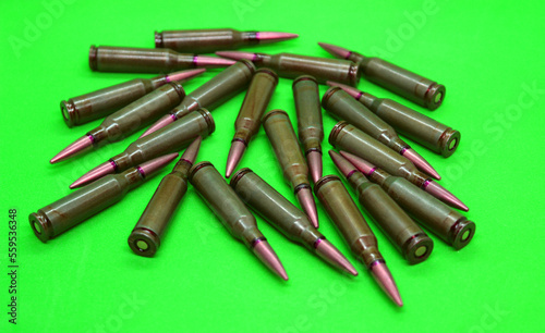 Scattering of unitary cartridges with red mark on a bullets studio isolated on a green surface 