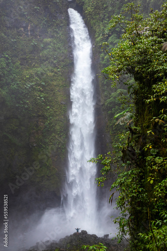 girl standing in front of san fernando waterfall in costa rica  huge waterfall in the middle of tropical rainforest  highest waterfall in costa rica  hidden gems of costa rica