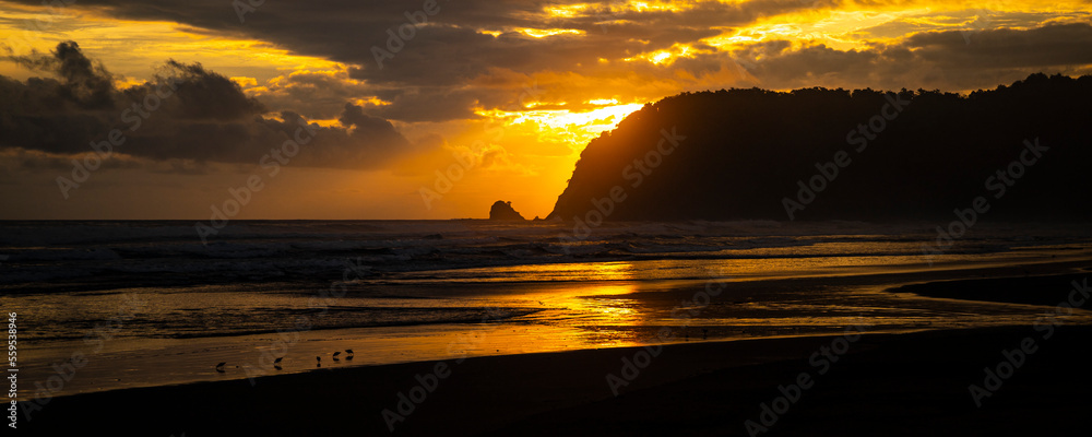 Obraz premium panorama of paradise Costa Rica beach at sunset; colorful sunset on tropical san miguel beach over the pacific