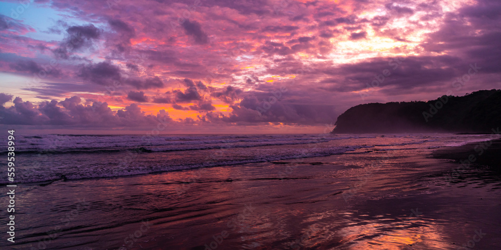 Obraz premium panorama of paradise Costa Rica beach at sunset; colorful sunset on tropical san miguel beach over the pacific