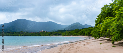 panorama of the famous conchal beach over the pacific in costa rica; paradise beach with turquoise water and green hills in the background photo