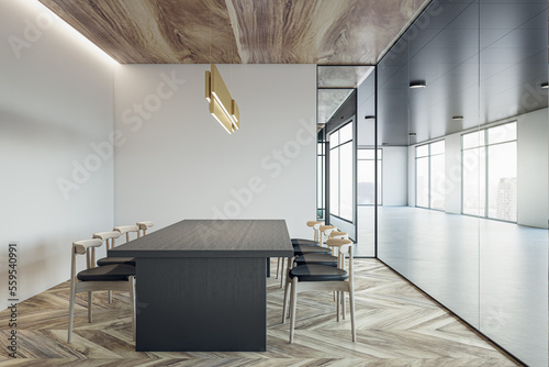 Fototapeta Side view on empty dark wooden conference table surrounded by chairs on parquet floor in meeting room with stylish chandelier on light wall background and glass wall