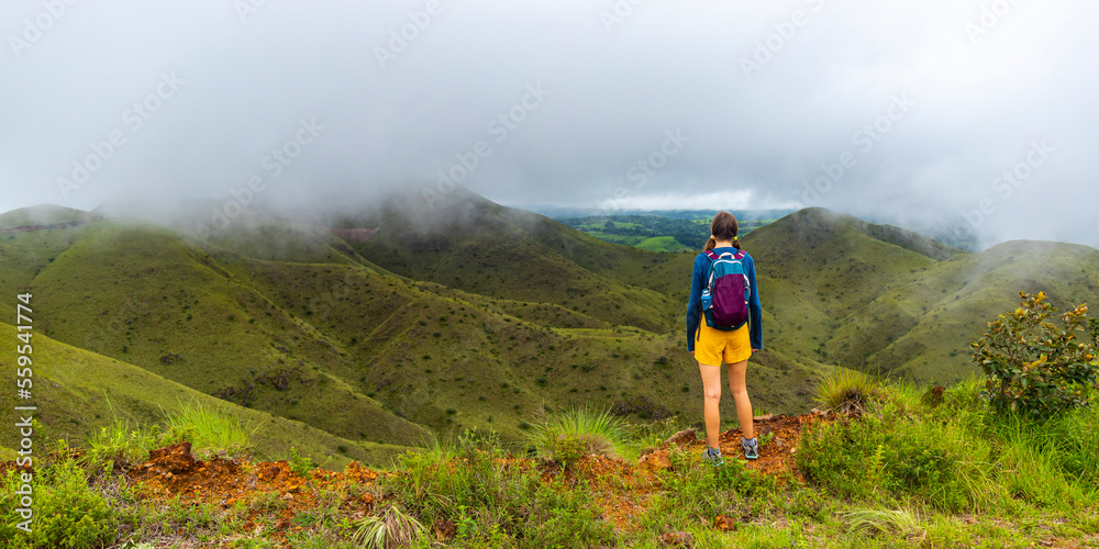 Obraz premium backpacker girl walks along ridge amid cerro pelado mountains during cloudy, misty weather; hiking in green mountains in Costa Rica, Costa Rica rainforests