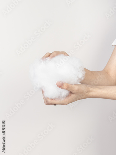 Woman holds a holofiber. Filler for pillows, blankets and clothes photo