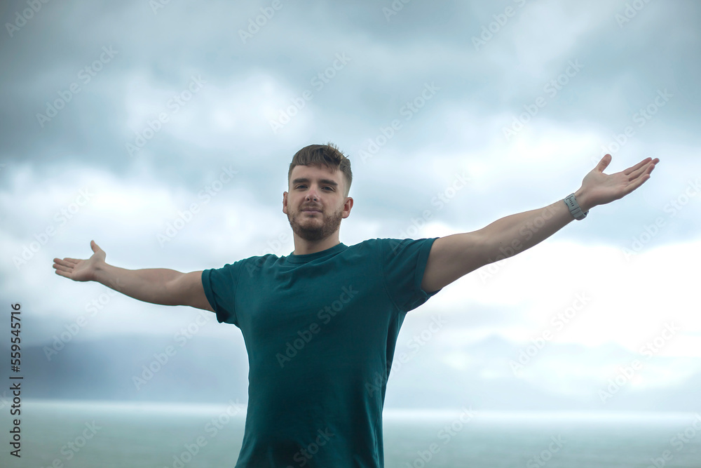 happy handsome free guy, young calm relaxed carefree man traveler with open raised hands enjoy sea, ocean view, person feeling good, breath deep deeply fresh air. Freedom, travel, happiness concept