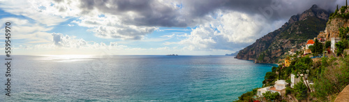 Fototapeta Naklejka Na Ścianę i Meble -  Touristic Town, Positano, on Rocky Cliffs and Mountain Landscape by the Tyrrhenian Sea. Amalfi Coast, Italy. Cloudy Sky Art Render. Panorama