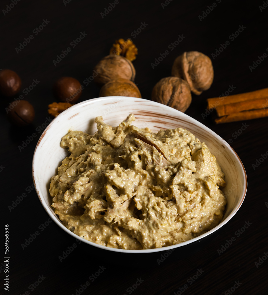Satsivi, a Georgian poultry dish in a walnut sauce. Close-up of whore Satsivi on a dark background Satsivi, a Georgian poultry dish in a walnut sauce. Close-up of whore Satsivi on a dark background